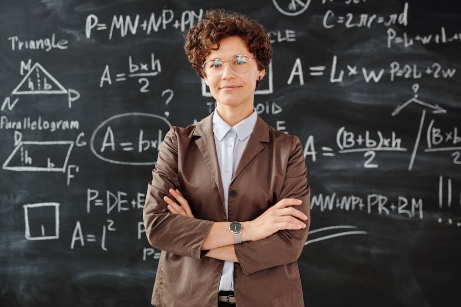 Confident female teacher standing with arms crossed in front of a detailed mathematical blackboard.